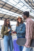Happy diverse group of young tourists checking passports and smiling while waiting for their train