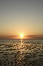 Sunset over the Wadden Sea on the German North Sea coast, low sun over Neuwerk, typical ripple