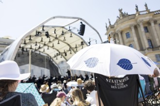Audience with sun protection at the Staatsoper für alle, a free open-air concert with conductor