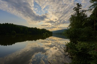 A quiet river with dramatic sky and clouds in the golden light of sunrise, summer, Grünenwört,