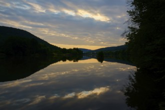 A calm river at dusk with dramatic clouds reflected in the water, summer, Grünenwört, Wertheim,