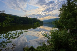 A dramatic sky reflected in a quiet river, surrounded by lush trees, summer, Grünenwört, Wertheim,