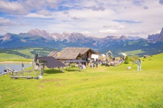 Film set in front of a mountain landscape with green meadow and cloudy sky, Edelweiss Hut, Alpe di