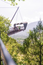 People on a floating platform in a mountainous landscape with green surroundings, Botanical Garden,