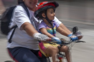 Woman and kid riding a bicycle, Photo with motion blur, City of Quito, Pichincha province, Ecuador,