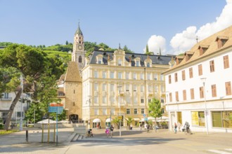 Sunny city view with historic buildings and church tower in the centre, under a clear sky, Merano,