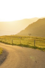 Landscape with rolling hills, a meadow and a cable car at sunset, Alpe di Siusi, Dolomites, South