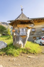 Whimsical wooden petrol station in a rural setting with car and meadow, Alpe di Siusi, Dolomites,