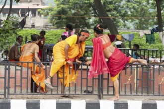 Devotees try to cross a divider as they arrives to visit Kamakhya Temple during Ambubachi Mela, in