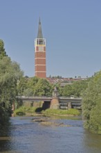 Town church built in 1968 and Auerbrücke bridge with rafters' monument over the River Enz,