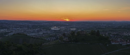 Panoramic view of a city at sunset with vineyards in the foreground and orange sky, Grabkapelle,
