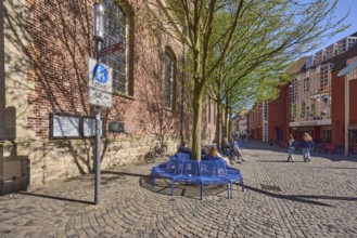 Pedestrian zone, traffic sign, benches, trees, brick building, facade, seated persons as secondary
