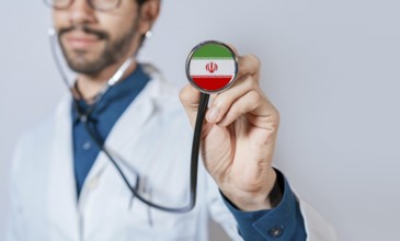 Doctor holding stethoscope with Iran flag. Iran health and care concept, Iran flag on stethoscope
