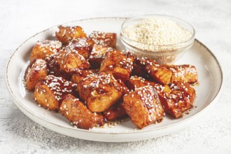 Fried pieces of salmon teriyaki with sesame seeds, top view