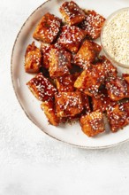 Fried pieces of salmon teriyaki with sesame seeds, top view