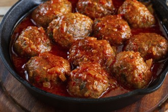 Minced meat meatballs, in tomato sauce, in a cast-iron pan, homemade, no people