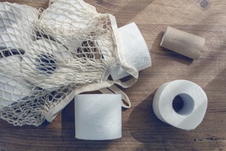 Mesh bag on the table, with rolls of toilet paper, top view, no people