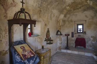 Interior view of a small chapel with icons and religious symbols on the wall, Agios Nikolaos