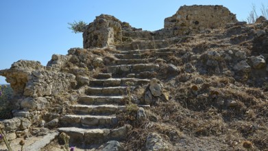 Dilapidated stone steps in an arid landscape dotted with ruins, Antimacheia, Medieval fortress, St