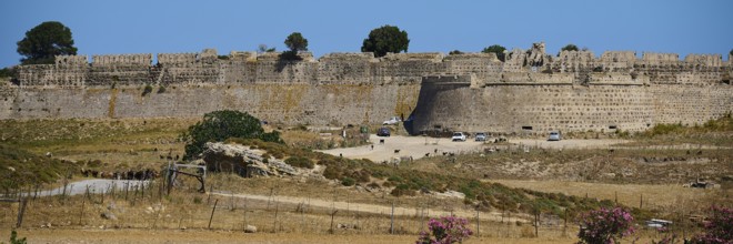 Mighty stone wall of a fortress under a blue sky with a wide entrance, Antimacheia, Medieval
