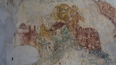 Faded fresco of a sacred figure on the wall of an ancient building, Chapel of Agios Nikolaos,