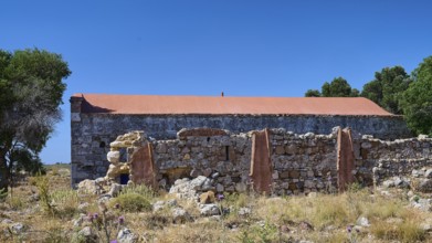 Stone walls of an abandoned building in a grassy landscape under a blue sky, Antimacheia, Medieval