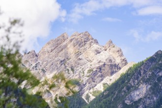 Mountain landscape with rocky peak and blue sky, surrounded by green nature, Alpe di Siusi, South