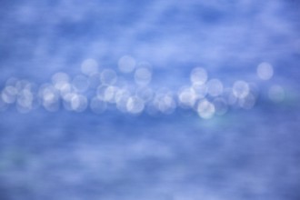 White light reflections, bokehballs on blue sea, water surface, Germany