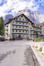 A large hotel in alpine surroundings with mountains and trees in the background, Lake Braies, South