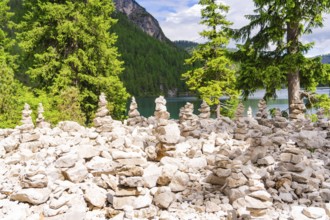Cairn in the forest with water in the background, natural environment, Lake Braies, South Tyrol,
