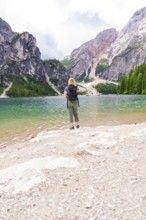 Woman with rucksack looking at the fascinating mountains and the clear lake in front of her, Lake