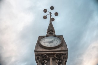 Low angle view of a clock tower in bordeaux, france, with a cloudy sky as backdrop, showcasing the