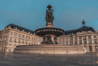 The fountain of the three graces graces place de la bourse in bordeaux, france, illuminated by the