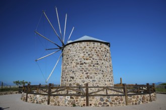 Historic stone windmill with fence and clear sky, Kefalos, Kos, Dodecanese, Greek Islands, Greece