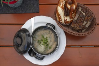Six sour tips with onions and pretzel, Franconian speciality served in a small enamel pot,