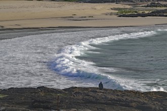 Rocky coast with crashing waves and lonely viewer under cloudy sky, Castlebay, Isle of Barra,