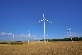 Wind turbines overlook a wide field under a clear blue sky, summer, Wenkheim, Werbach,