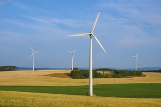 Wind turbines stand on fields stretching under a cloudy sky, summer, Höhefeld, Wertheim,