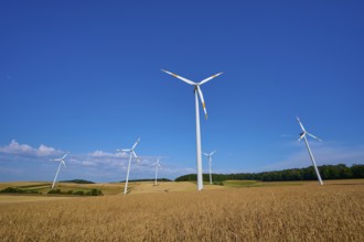 Several wind turbines standing on fields under a clear blue sky, summer, Wenkheim, Werbach,