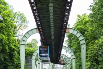 The Wuppertal suspension railway runs through Vohwinkel in front of buildings from the Wilhelminian