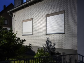 A detached house illuminated by a street lamp with the shutters down, night shot, Hilden, Germany