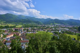 View of a district town surrounded by green hills under a cloudy blue sky, Waldkirch, Breisgau,