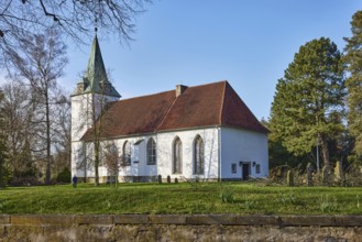 Evangelical Lutheran Church Hille, cemetery, sandstone wall, bare winter trees, blue cloudless sky,