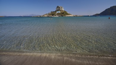 Clear blue sea with peaceful island in the centre of the picture, Agios Stefanos Beach, Agios