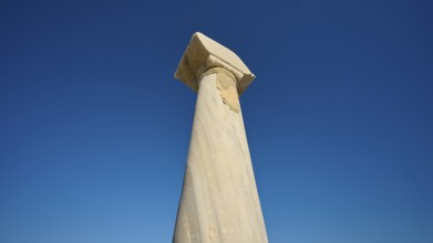 Ancient column imposing against deep blue sky, Agios Stefanos Beach, Agios Stefanos Basilica,