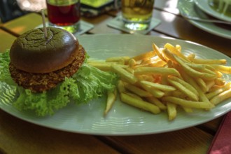 Hamburger with French fries, served in a beer garden, Franconia, Bavaria, Germany