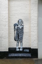 Smile artwork mural by Hendog of smiling girl child holding camera created 2021, Butcher Row,