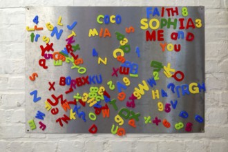 Plastic colourful magnetic letters and numbers on metal board, UK