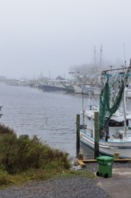 Commercial fishing boats in the harbor at Ocean Springs, Mississippi on a foggy morning