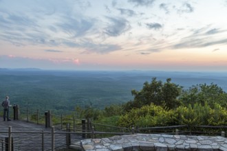 Man looking out over the valley at sunset from the Vista Cliffside Restaurant in Cheaha State Park